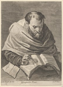 A mathematician seated at a table, working on mathematical equations