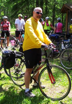 Author sporting a yellow cycling jersey straddling his bike.